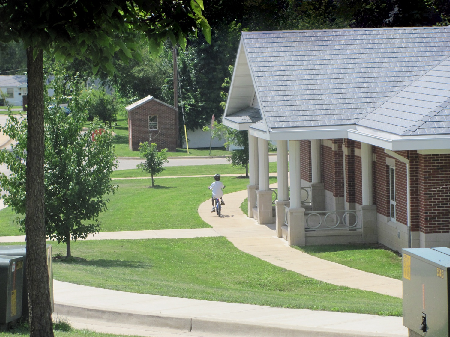 Young boy riding his bike past the residential treatment center on campus