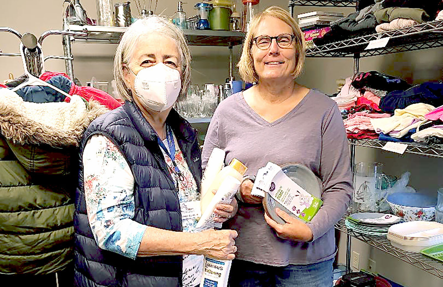 Two women organizing household items in the Hope Chest, a supply area for those once homeless.