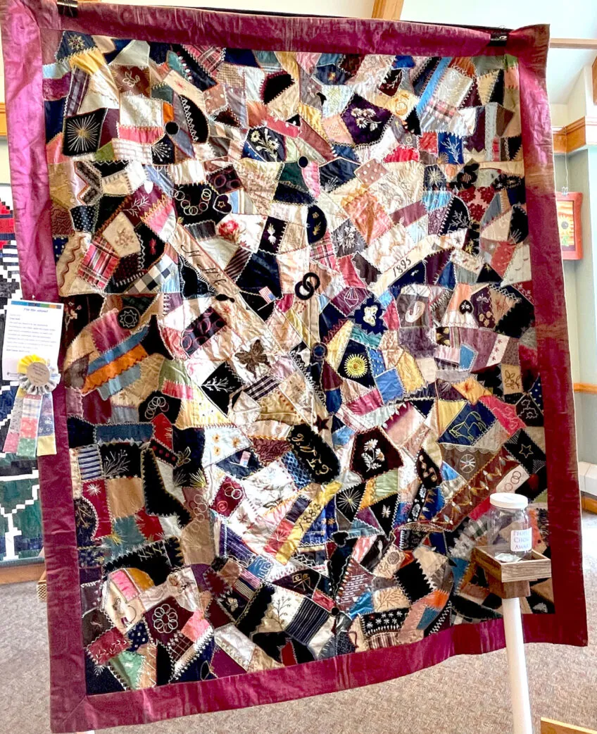 Beautiful show quilt featuring a variety of colors and patch-like pieces of material with different images on them