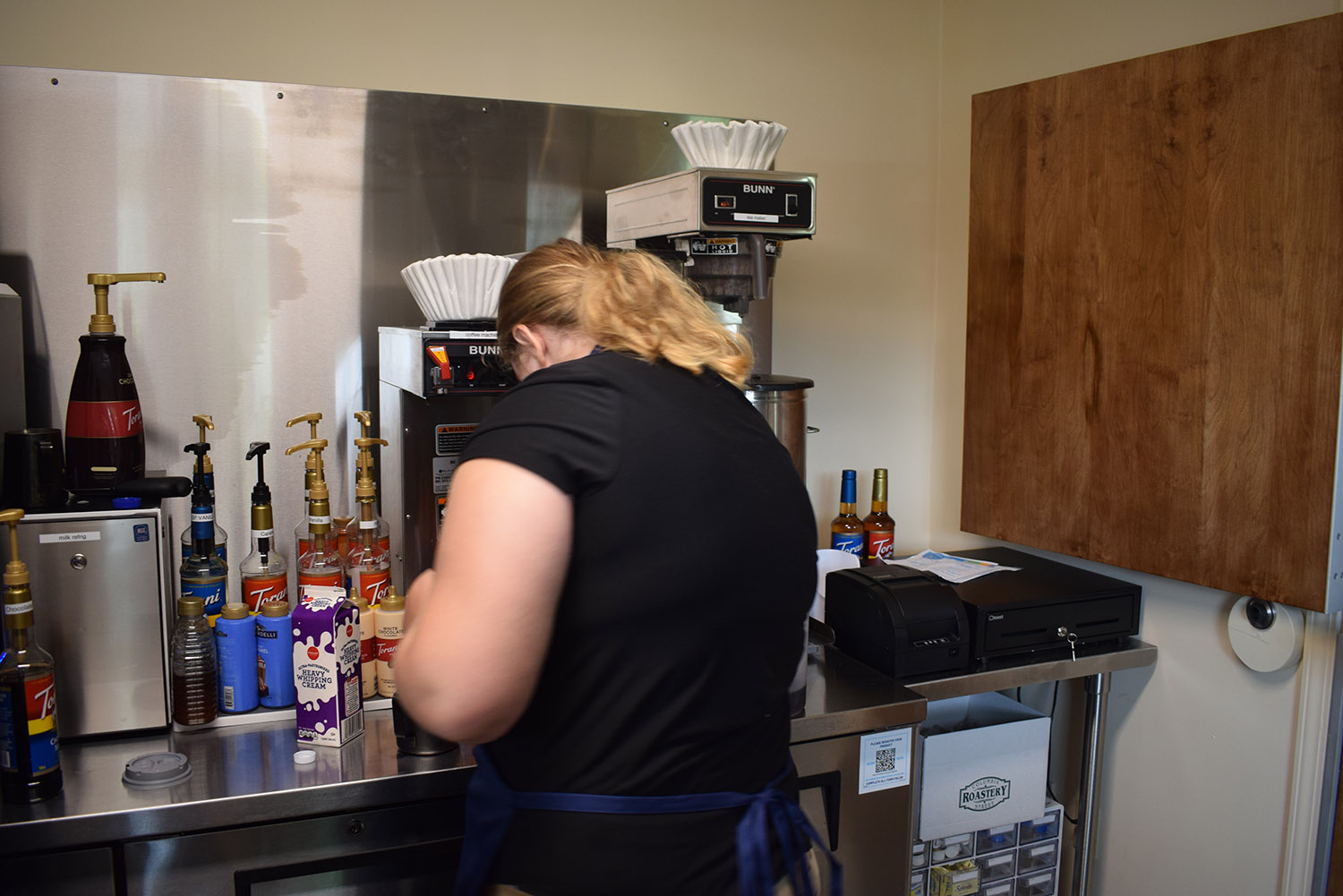 Female worker making a drink in a coffee shop