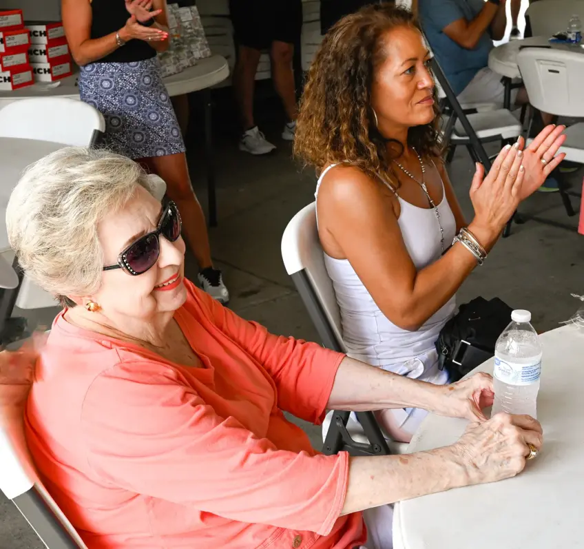 Mary Henson and Wendy Gill sitting at table at Kendall Gill Golf benefit.