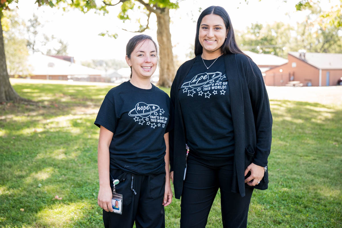 Two female youth care professionals standing next to each other