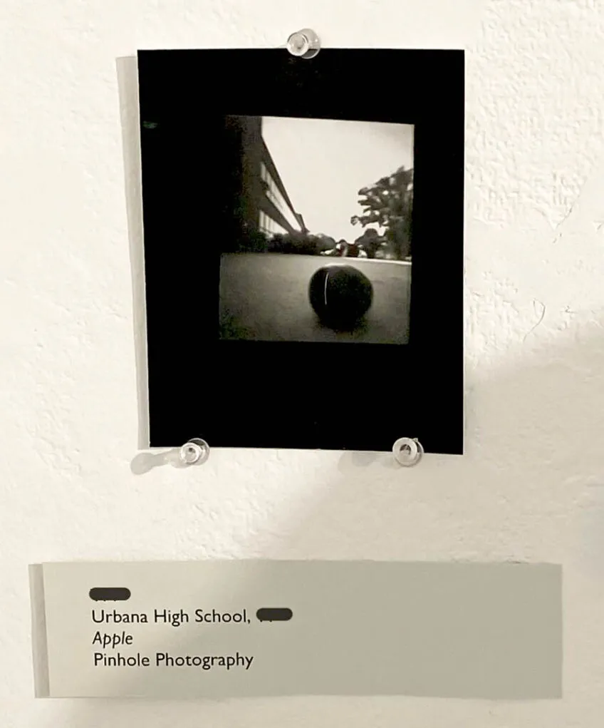 black and white photo pasted on a black foam board and hanging on a wall with a pushpin