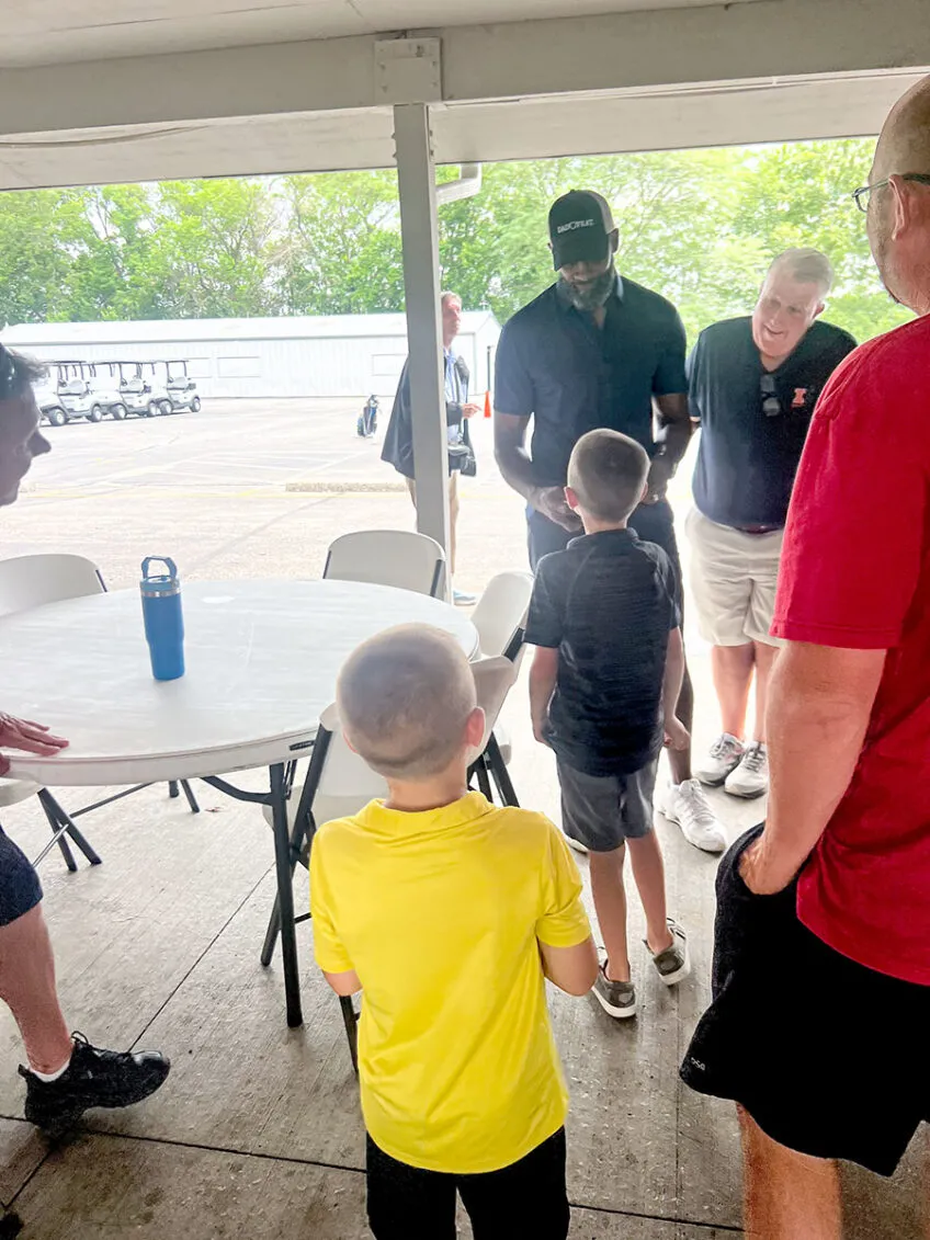 young boys in tshirts and shorts getting autographs from kendall gill